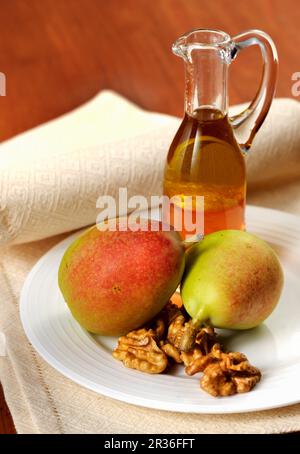 Una disposizione di pere, dadi e liquore Foto Stock