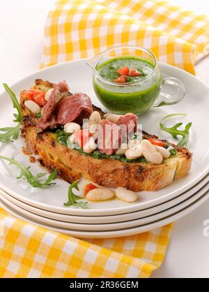 Crostino al pesto, carne in scatola e fagioli cannellini Foto Stock