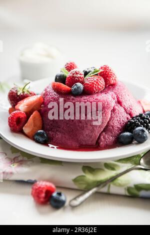 Budino estivo su un piatto con frutti di bosco freschi Foto Stock