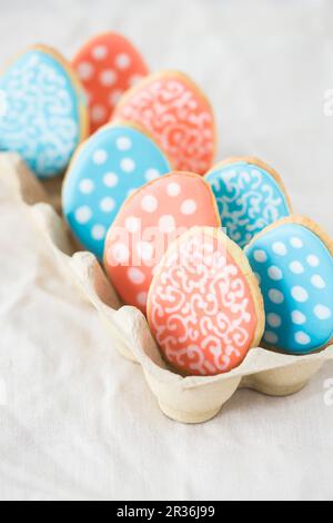 Biscotti d'uovo di Pasqua colorati in una scatola d'uovo Foto Stock