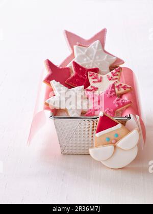 Biscotti di Natale a forma di stella in una lattina di pane accanto a un biscotto di Natale del Babbo Natale Foto Stock