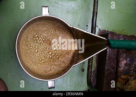 Olio di semi di zucca appena spremuto che scorre in un secchio Foto Stock