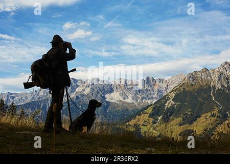 Un cacciatore con un cane in un ambiente di montagna Foto Stock