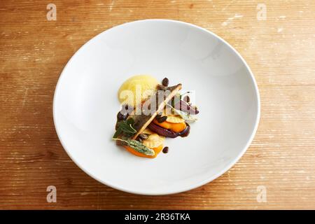 Filetto di carro con ravioli di zucca, burro di salvia e cipolle brasate in vino rosso Foto Stock