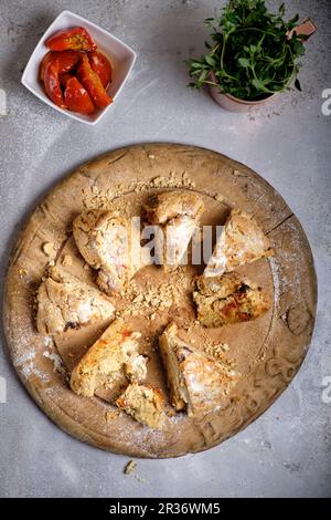 Pane irlandese soda a fette con pomodori e timo su un asse di legno Foto Stock