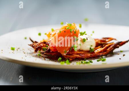 Vitelotte Rösti (fritte Swiss torte di patate) con la crème fraîche e salmone Foto Stock