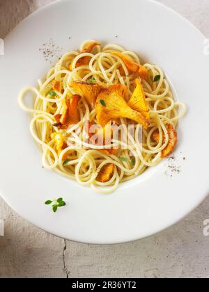 Spaghetti con funghi finferli saltati in burro ed erbe aromatiche Foto Stock