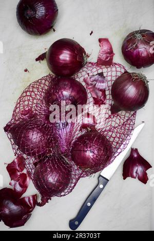 Cipolle rosse in una rete Foto Stock