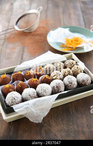 Tartufi assortiti della sfera di Bliss su carta in una scatola di cioccolato Foto Stock