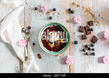 Una ciotola frullato con frutti di bosco e i dadi Foto Stock