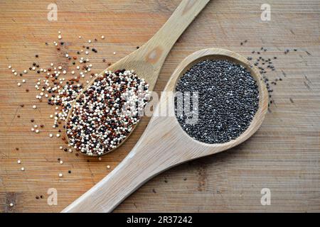 Semi di quinoa e chia su un cucchiaio di legno Foto Stock
