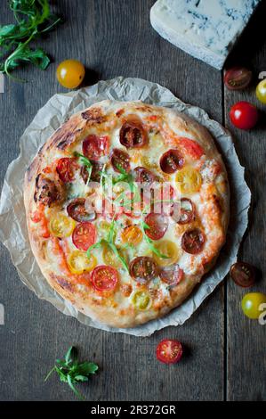 Pizza fatta in casa con pomodori ciliegini colorati, mozzarella e gorgonzola Foto Stock