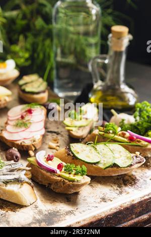 Bruschetta con vari condimenti su un tavolo rustico Foto Stock