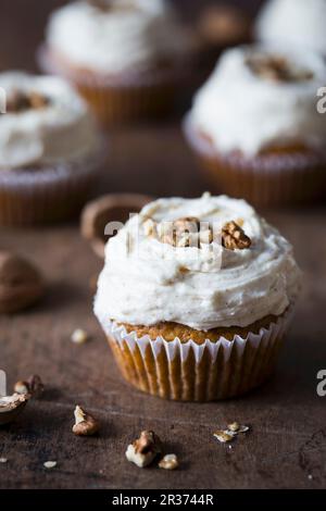 Cupcake di zucca con glassa di formaggio cremoso e noci. Foto Stock