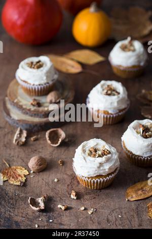 Cupcake di zucca con crema di formaggio glassa e noci. Foto Stock