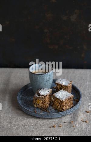 Un brownie con una piccola tazza di cappuccino su una coperta di lino Foto Stock