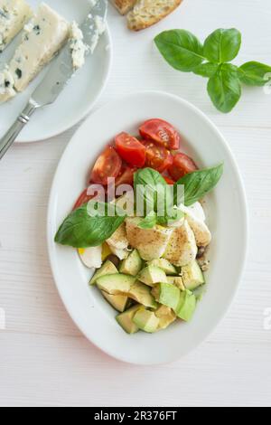 Pomodori, mozzarella e avocado al basilico Foto Stock