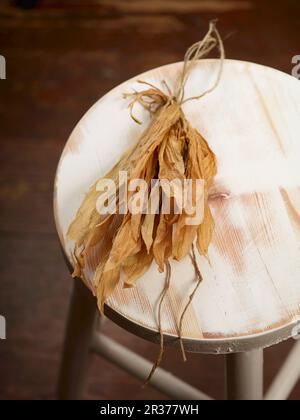 Foglie di aglio selvatico secco su una sedia di legno Foto Stock