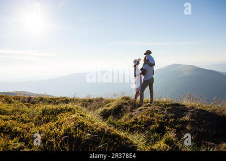 La famiglia ammira il paesaggio montano Foto Stock