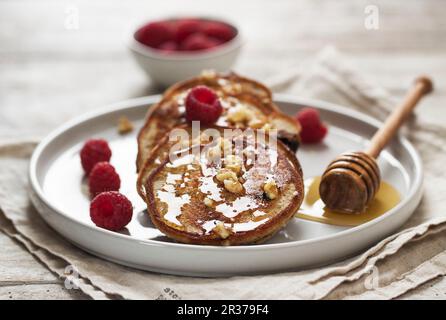 Quark e frittelle di farina di grano saraceno con mirtilli, lamponi e un dado di miele topping Foto Stock