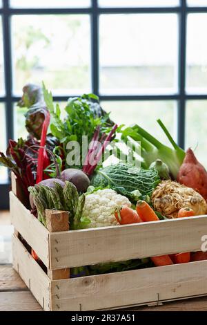 Una cassa di verdure davanti ad una finestra Foto Stock