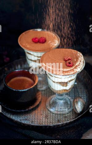 Il tiramisù è irrorato con il cacao in polvere Foto Stock