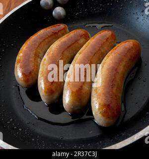 Bangers inglesi (salsicce per la colazione) in padella Foto Stock