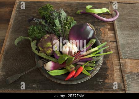 Una ciotola di verdure con melanzane, carciofi, aglio e peperoncini Foto Stock