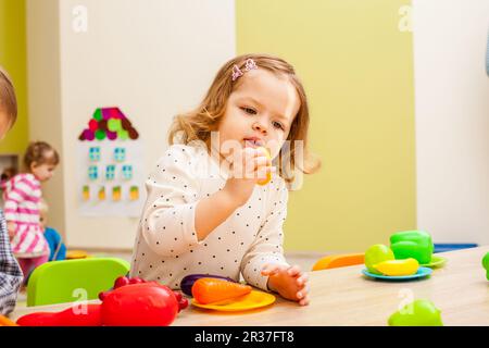 La ragazza gioca con frutta Foto Stock