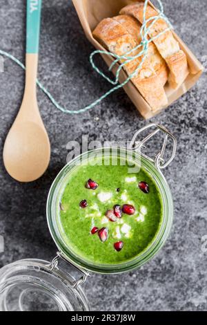 Verde zuppa di cavolo cappuccio in un vasetto di vetro con i semi di melograno e cubetti di feta Foto Stock