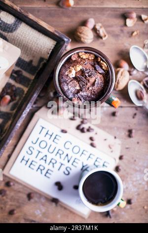 Torta al cioccolato con noci e caffè servito su un tavolo di legno Foto Stock