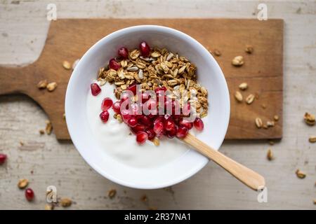 Yogurt con granola e i semi di melograno Foto Stock