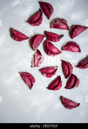 Gnocchi di barbabietole asiatiche su una superficie di lavoro infarinata Foto Stock