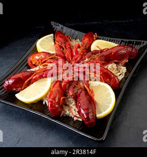 Gamberi cotti con limoni su riso selvatico Foto Stock