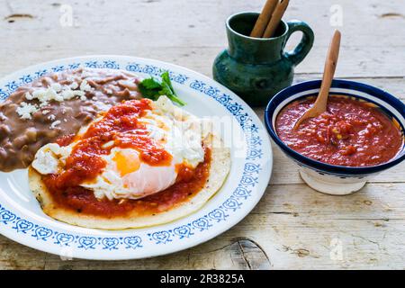 Huevos Rancheros (uova fritte su una tortilla di mais con fagioli arrosto e salsa di pomodoro, Messico) Foto Stock