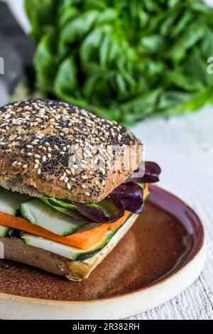 Un hamburger vegano con verdure fresche su sfondo rustico Foto Stock