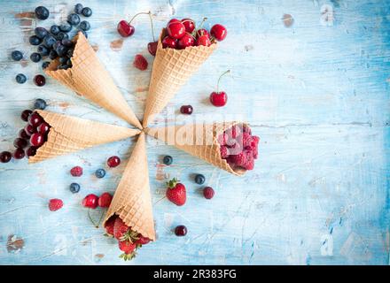Vari bacche e ciliegie in coni gelato Foto Stock