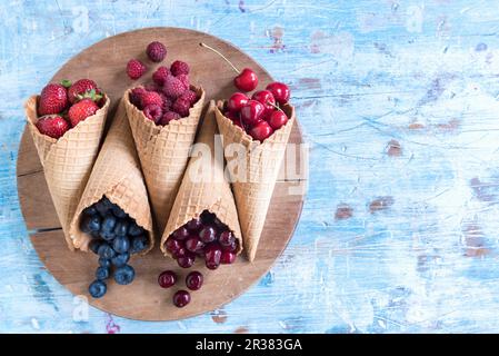 Vari bacche e ciliegie in coni gelato Foto Stock