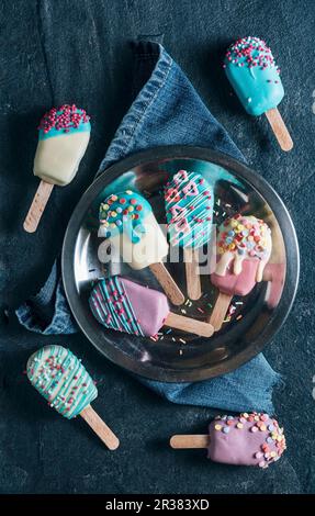 Viene visualizzata la torta a forma di ghiaccioli con Colorati luminosamente ciliegina (visto da sopra) Foto Stock