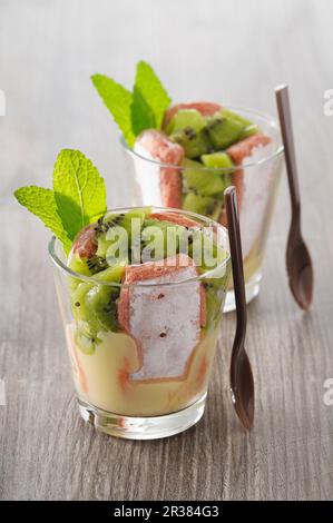 Charlottes in bicchieri con biscotti rosa de Reims e kiwi (Francia) Foto Stock