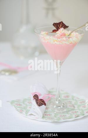 Dessert di crème rosa con panna montata in un bicchiere da cocktail Foto Stock