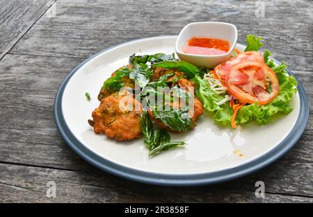 Piastra di gamberetti torte con insalata sul tavolo di legno Foto Stock