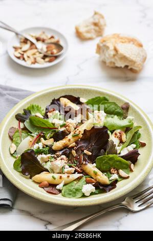 Insalata mista di foglie con punte bianche di asparagi e formaggio di pecora Foto Stock