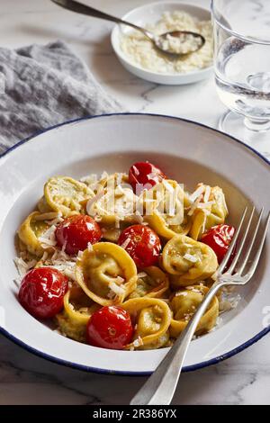 Tortellini di spinaci e ricotta fatti in casa con pomodori ciliegini Foto Stock