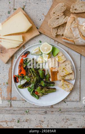 Peperoni fritti serviti con pane e formaggio (vista dall'alto) Foto Stock