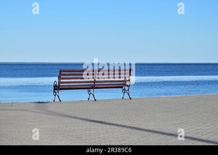 Sedile unico sul selciato riva del fiume Foto Stock