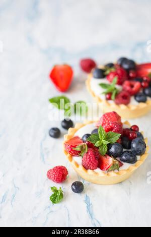 Crostate di frutti di bosco miste con crema alla vaniglia Foto Stock