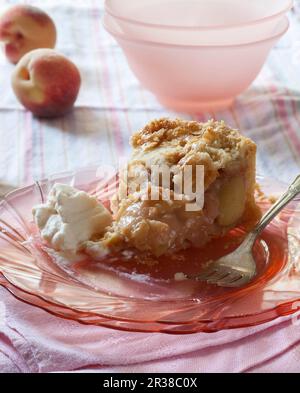 Pezzo di torta di Peach parzialmente mangiato con panna montata Foto Stock