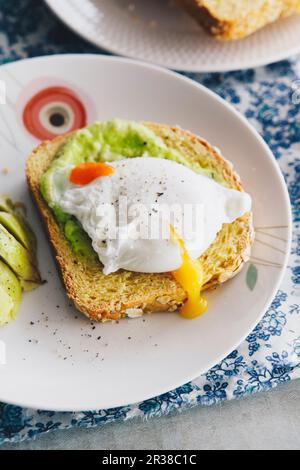 Pane di avena e patate dolci con avocado e uovo in camicia Foto Stock