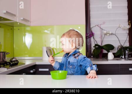 Il ragazzo amabile vuole provare la zuppa della madre Foto Stock